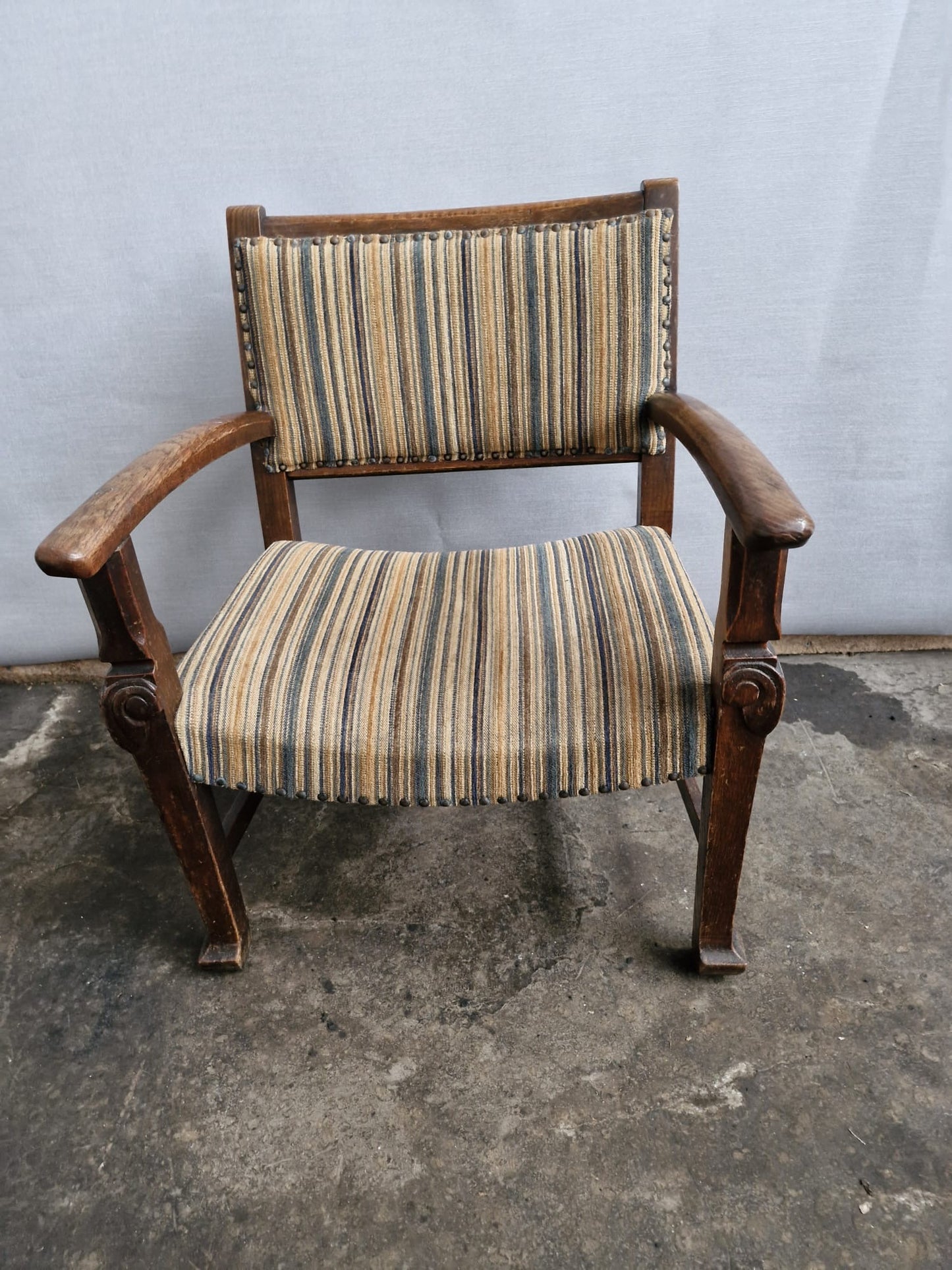 A Small vintage carved oak framed kids armchair with upholstered seat