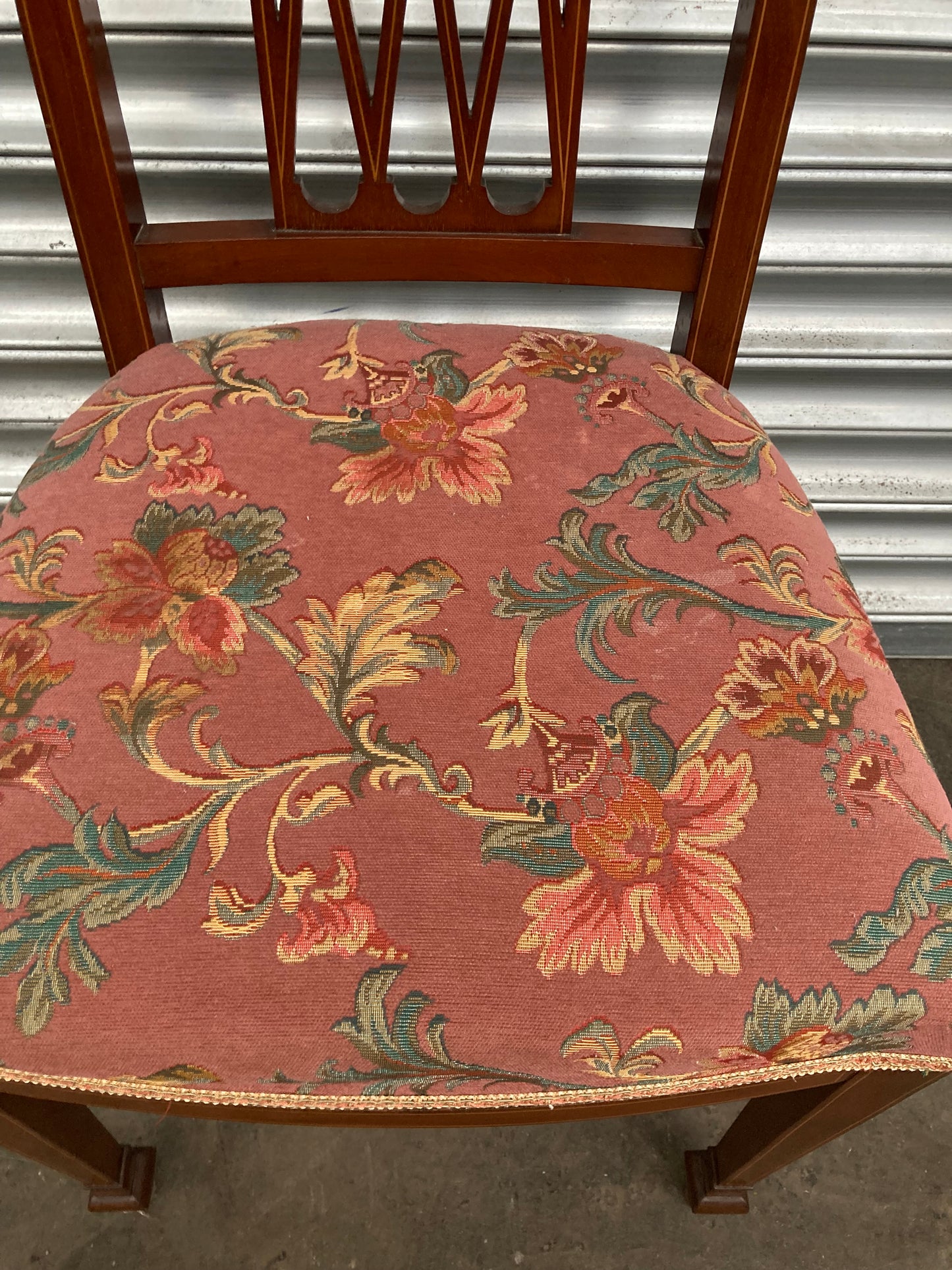 Single antique dining chair with floral seat and gold inlaid trim on back rest