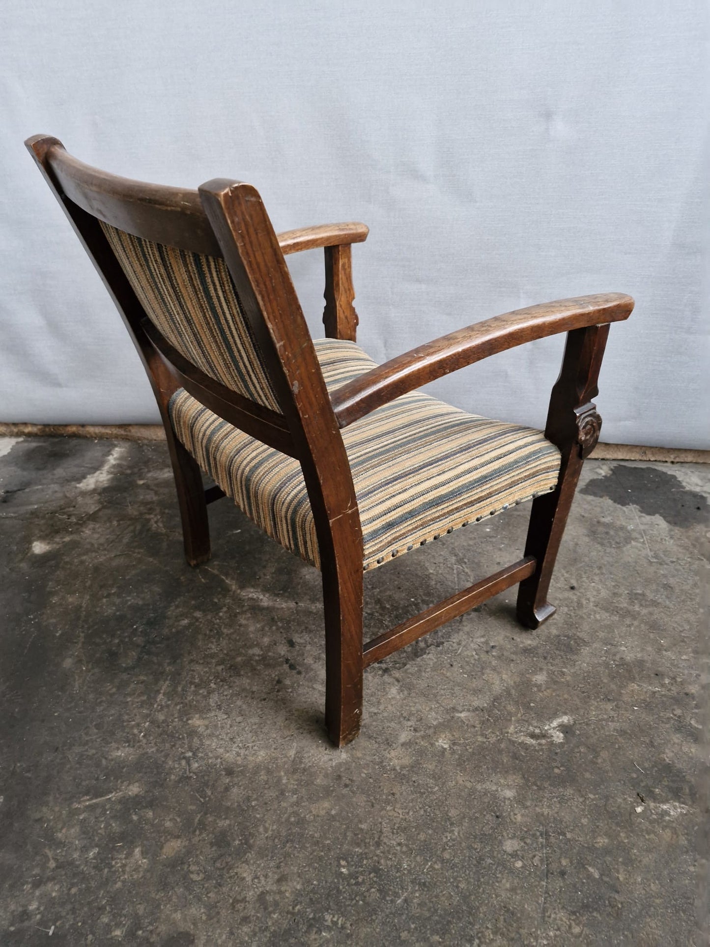 A Small vintage carved oak framed kids armchair with upholstered seat