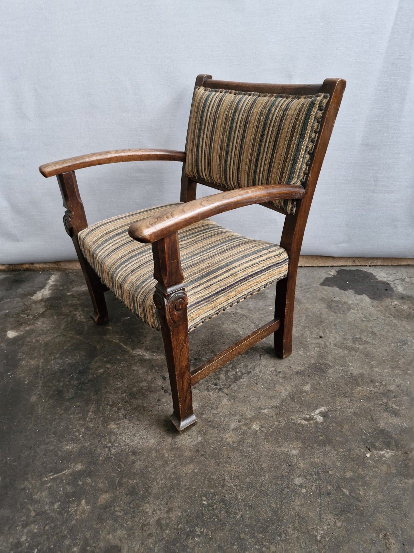 A Small vintage carved oak framed kids armchair with upholstered seat